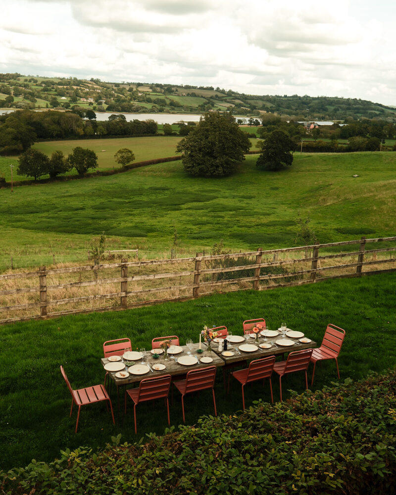 Long table laid up outside Heronmere with view over Blagdon Lake